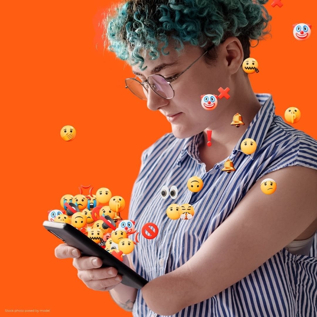 A person looks at their phone with emojis covering the screen A person looks at their phone with emojis covering the screen